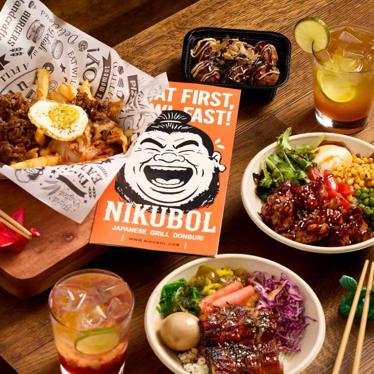 Dining table with Japanese cuisine, drinks, and a 'Nikubol' menu.